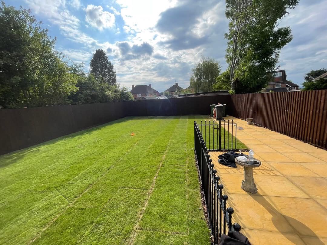 Garden with new lawn, patio and dark-stained fencing
