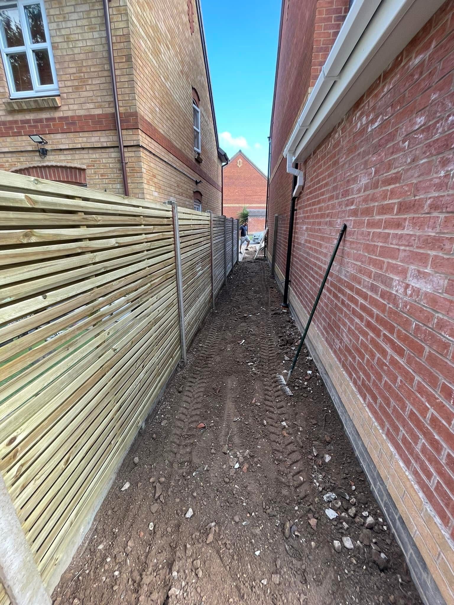 Slatted horizontal fence running down a side passage