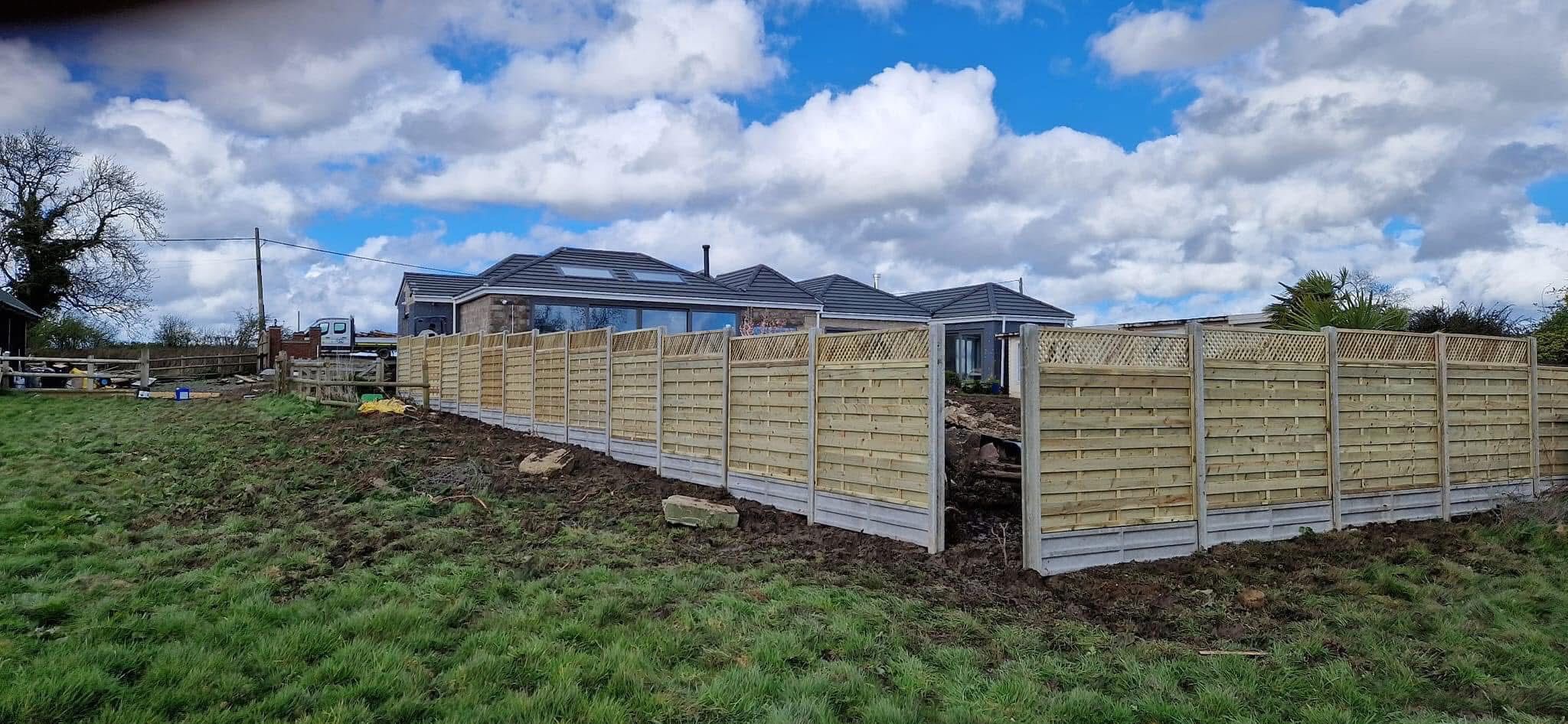 New panel fencing enclosing a large plot under a blue sky
